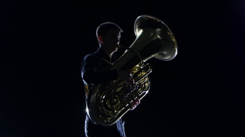 Man Plays on the Tuba Slow Melody in Black Studio