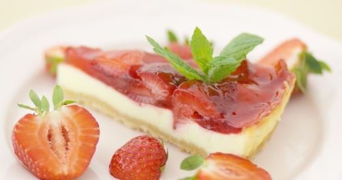 Strawberry Cheesecake with Fresh Mint Garnish on Plate