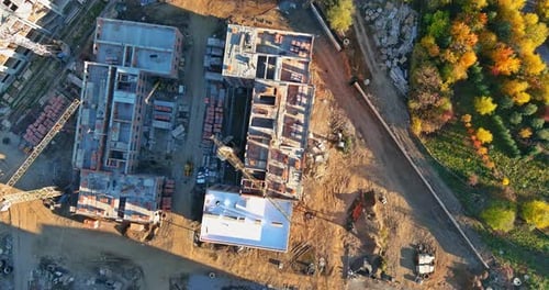 Vista panorámica desde arriba de varias grúas de construcción de diferentes alturas en un sitio de construcción durante