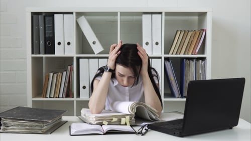 Woman Tired of Paperwork, Putting Head on Hands at Workplace