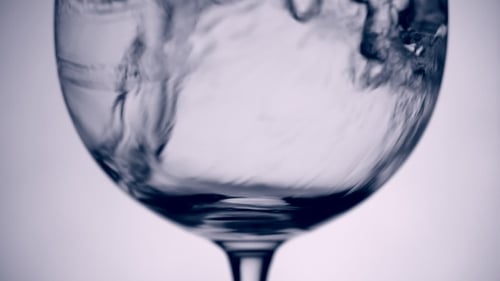 In Glas gegossenes Wasser auf weißem Hintergrund
