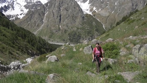 Female Trekker Walks on Mountain Trail