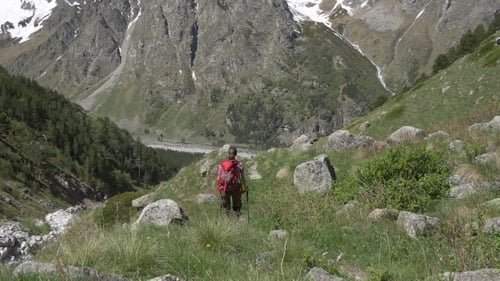 Woman Hiking Through Mountainous Landscape