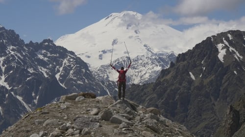 Excited Woman on Top of Mountain