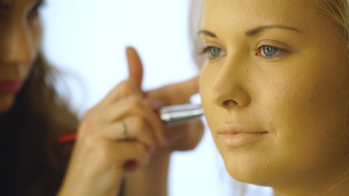 Woman Having Makeup Applied by Makeup Artist