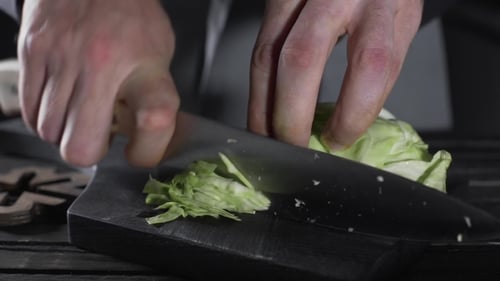 Chefkoch zerkleinert Kohl für Gemüsesalat, vegetarische Mahlzeit, veganes Essen, Kochen, Vitamine und