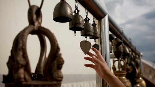 Woman Touching Sacral Bells in Wat Saket Ratcha Wora Maha Wihan (The Golden Mount). Bangkok Thailand