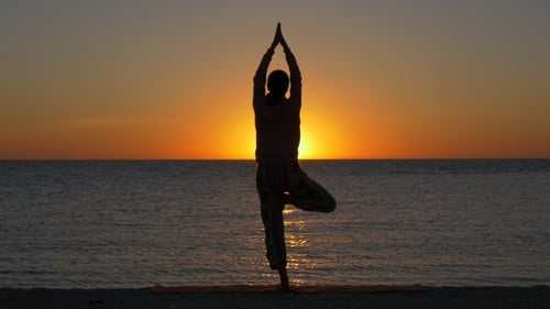 Woman in Yoga Pose on the Beach at Sunset