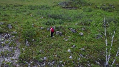 Girl Traveler Goes Through a Meadow