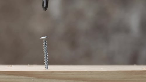Power Drill Driving Screw into Wood Close Up