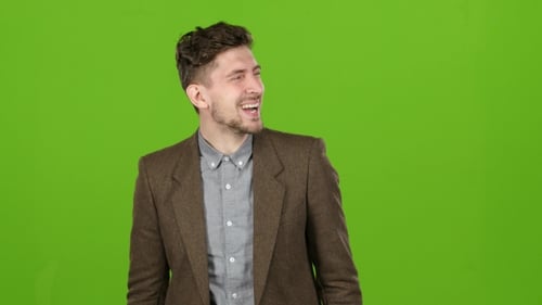Businessman Stands and Smiles, a Joke Makes Him Laugh. Green Screen
