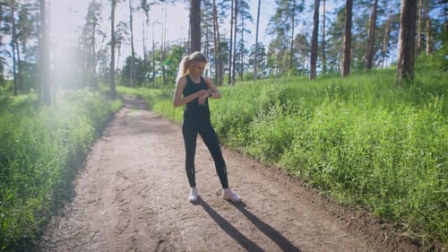 Girl Checking Time and Pulse on Pathway in Summer Forest