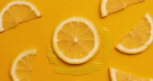 Top view rotation of fresh slice of lemons juice and gel serum pours