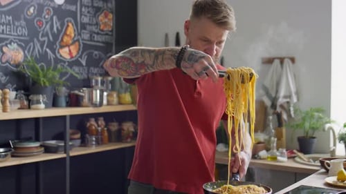 Man Prepares and Plates Pasta in Bright Kitchen