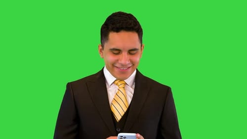 Man in Suit Smiling at Cellphone on Green Screen
