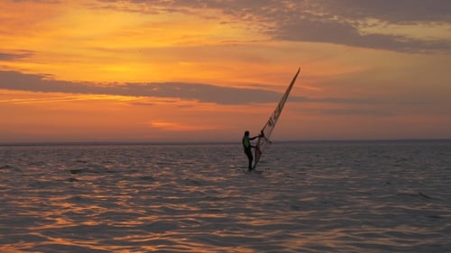 Windsurfer Glides at Sunset on Open Water
