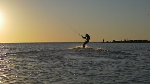 Kite Surfer Glides Across Ocean at Golden Hour
