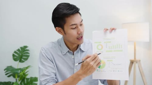 Asian businessman presentation to colleague about plan in video call in office.