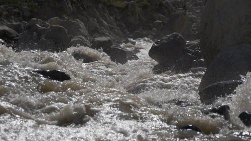 Schnelles Plätschern des Mountain River an riesigen Steinen