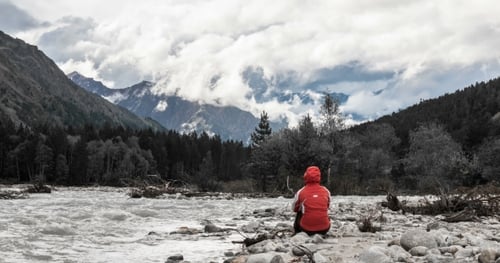 Person by River in Beautiful Mountain Landscape