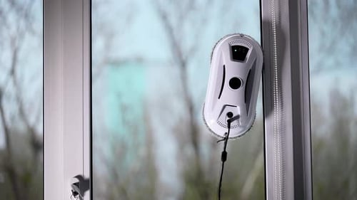 Der automatische Roboterassistent wäscht das Glas des Fensters