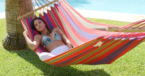 Woman Relaxing in a Hammock by the Pool
