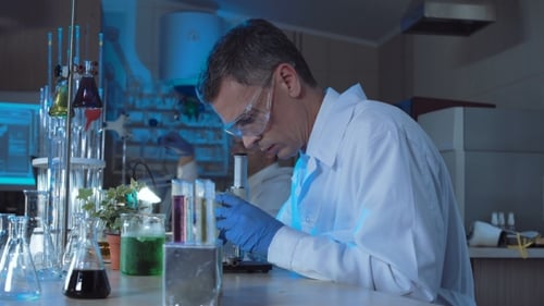 Scientist Working With Microscope in Brightly Lit Lab