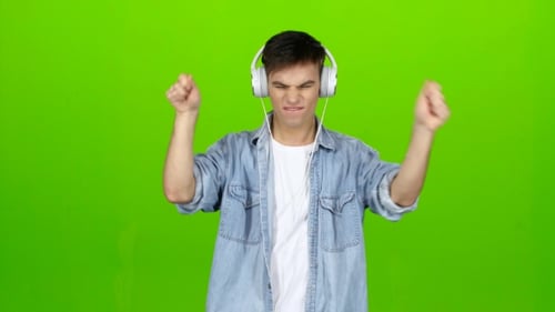 Guy Listens To Energetic Music in Headphones and Dances. Green Screen