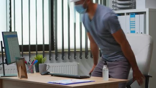 Man in Mask Working in an Office