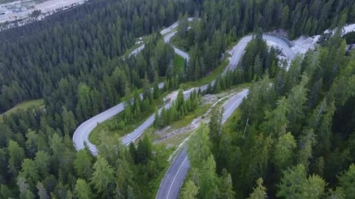 Aerial View of Winding Road in the Mountains and Green Forest