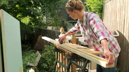 Woman Measures Wood in Sunny Suburban Yard