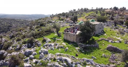 Vue aérienne de personnes dans l'ancienne structure au milieu des collines, Bi'r Saricah.