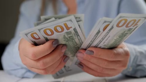 Woman Counts Stack of Hundred Dollar Bills