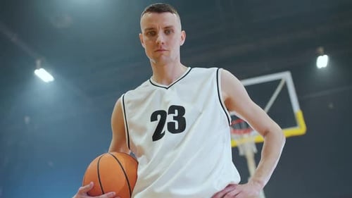 Portrait d'un joueur de basket-ball caucasien regardant sérieusement le championnat de basket-ball avec caméra