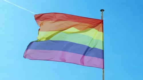 Pride Flag Waving in Blue Sky