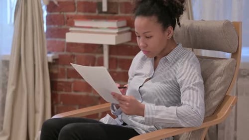 Woman Reviewing Documents and Having an Idea