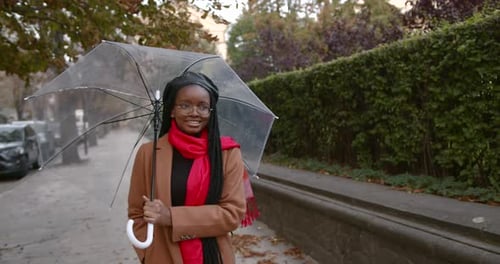 Black Girl with an Umbrella in the Middle of the Autumn Street
