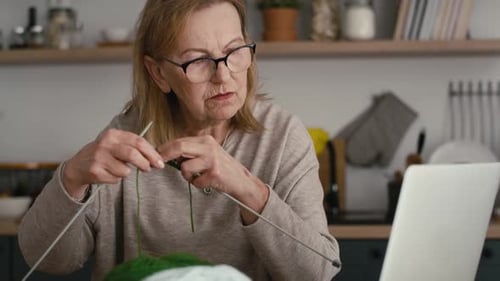 Woman Knitting at Home in the Kitchen