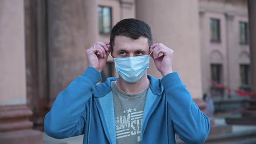 Man Taking Off Medical Mask Outdoors