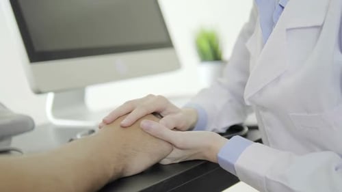 Doctor Comforts Patient by Holding Their Hand