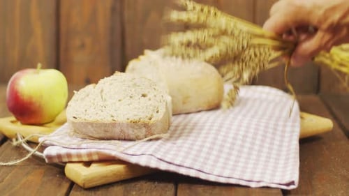 Bread, Apple, and Wheat on Wooden Table