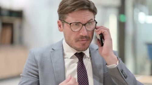 Frustrated Man on Phone Call in Office