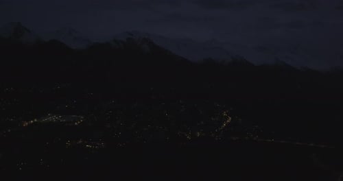 Helicopter aerial panning over hilly landscape and small river, cloudy day