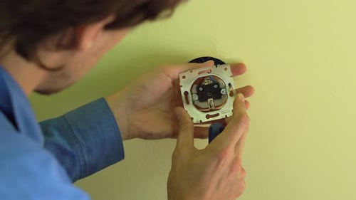 Closeup Shot of Young Professional Electrician Doing Socket Installation.