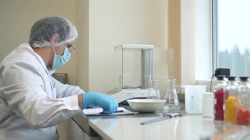 Un pharmacien travaille avec des échantillons de médicaments et rédige un rapport à la table du laboratoire Spbd