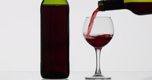 Vin rosé. Vin rouge verser dans un verre à vin sur fond blanc
