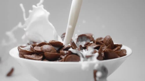 Milk Poured Into Bowl of Chocolate Cereal