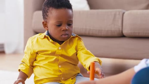 Mãe e bebê brincando com blocos de brinquedo em casa 19