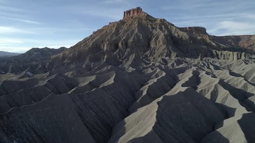 Flying along ridge of dune rising high to the top of a desert mesa