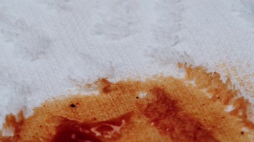 Red Liquid Stain Spreads Across White Terrycloth Towel